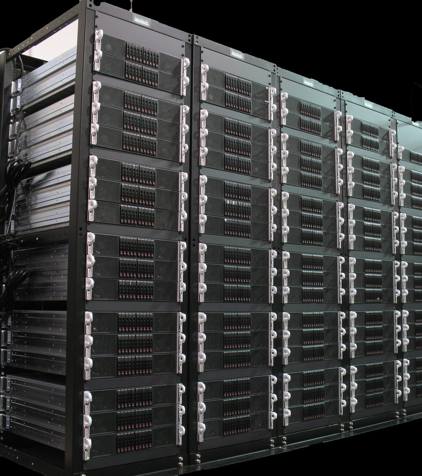 Cluster-Rack-1361x1536 Rows of black server racks in a data center.