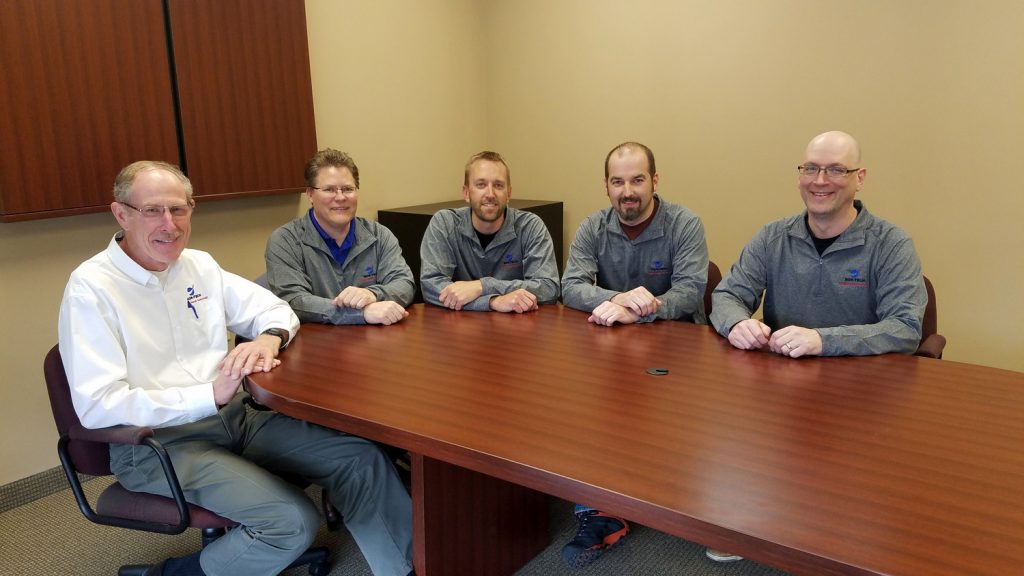 Five men sitting at a conference table. Five men sitting at a conference table.