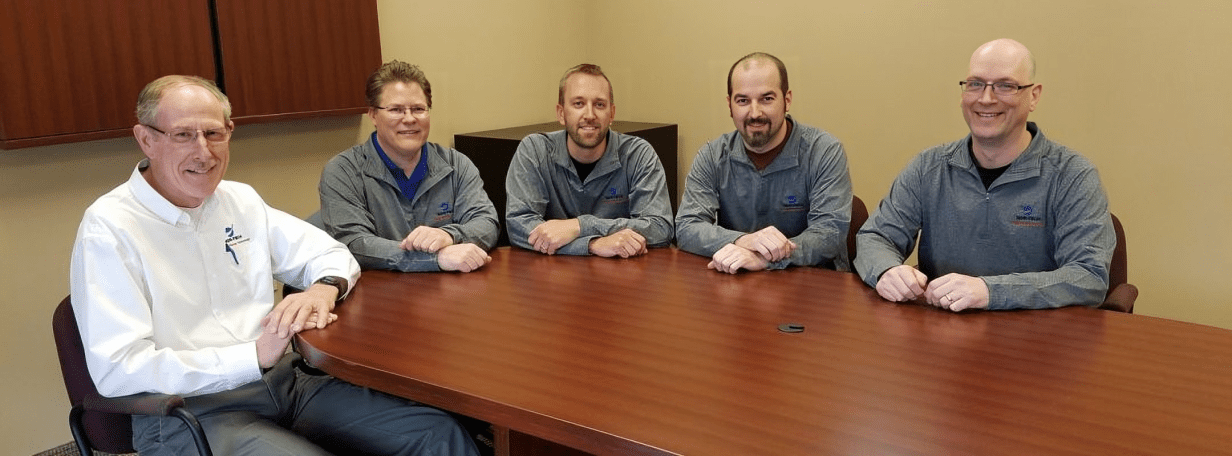 Five men sitting at a conference table. Five men sitting at a conference table.
