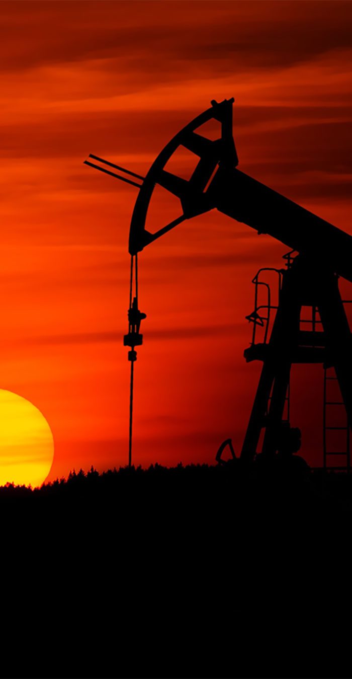 Oil pumpjack silhouetted against vibrant sunset. Oil pumpjack silhouetted against vibrant sunset.