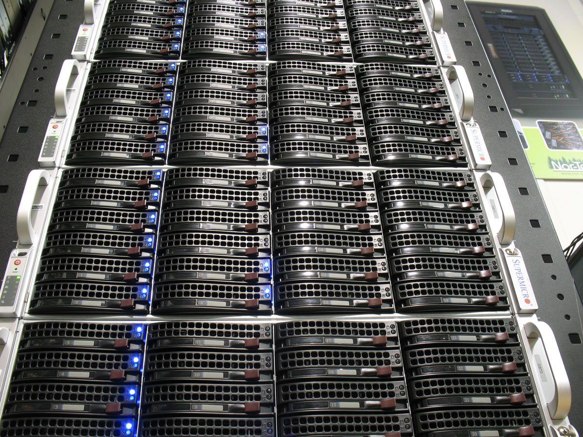 Rack-mounted servers with glowing indicator lights. Rack-mounted servers with glowing indicator lights.