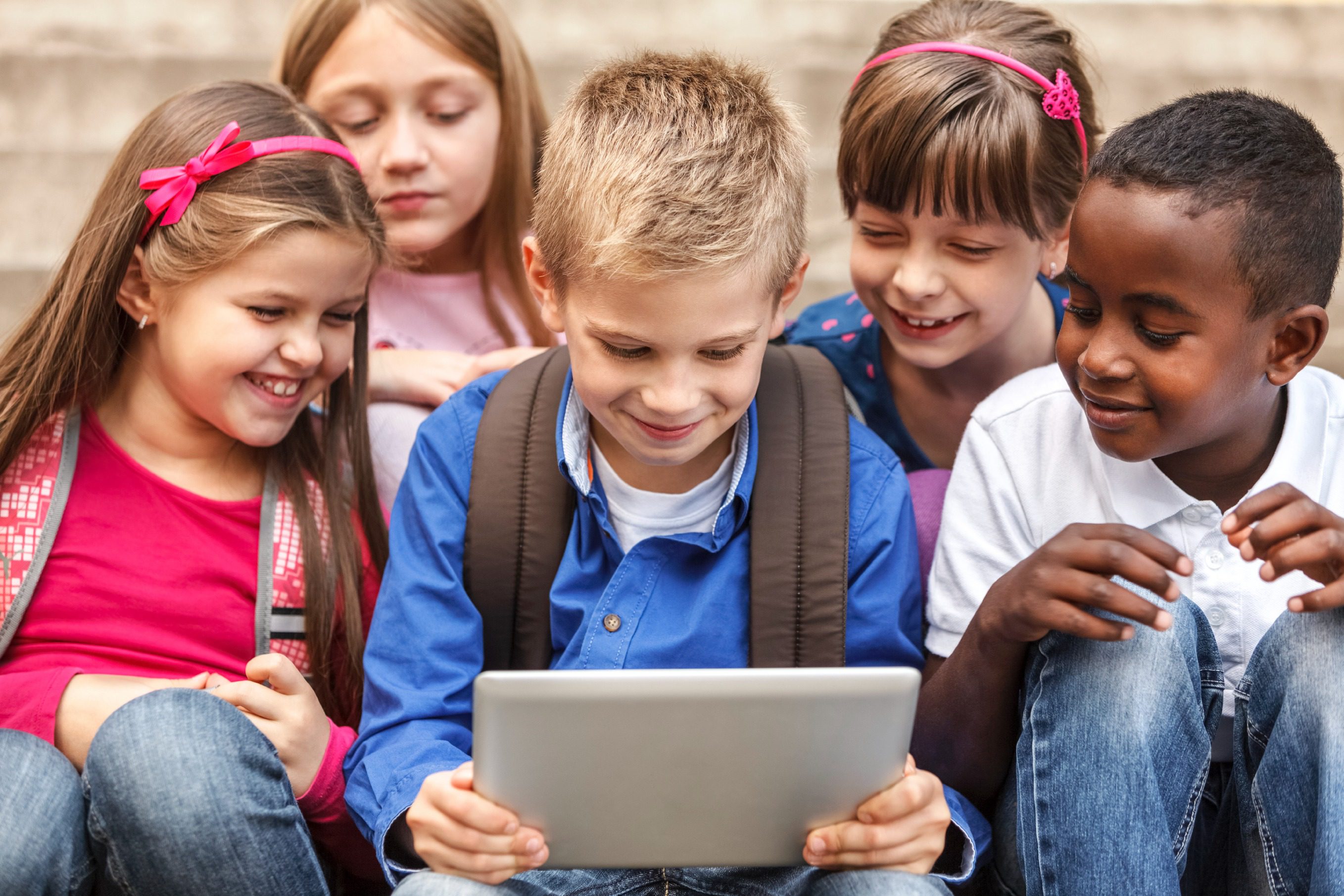 imgi_3_tablet2 Group of children excitedly watching a tablet together.
