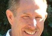 Smiling man outdoors in a suit.