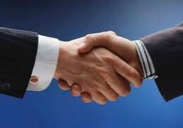 Business handshake against a blue background.